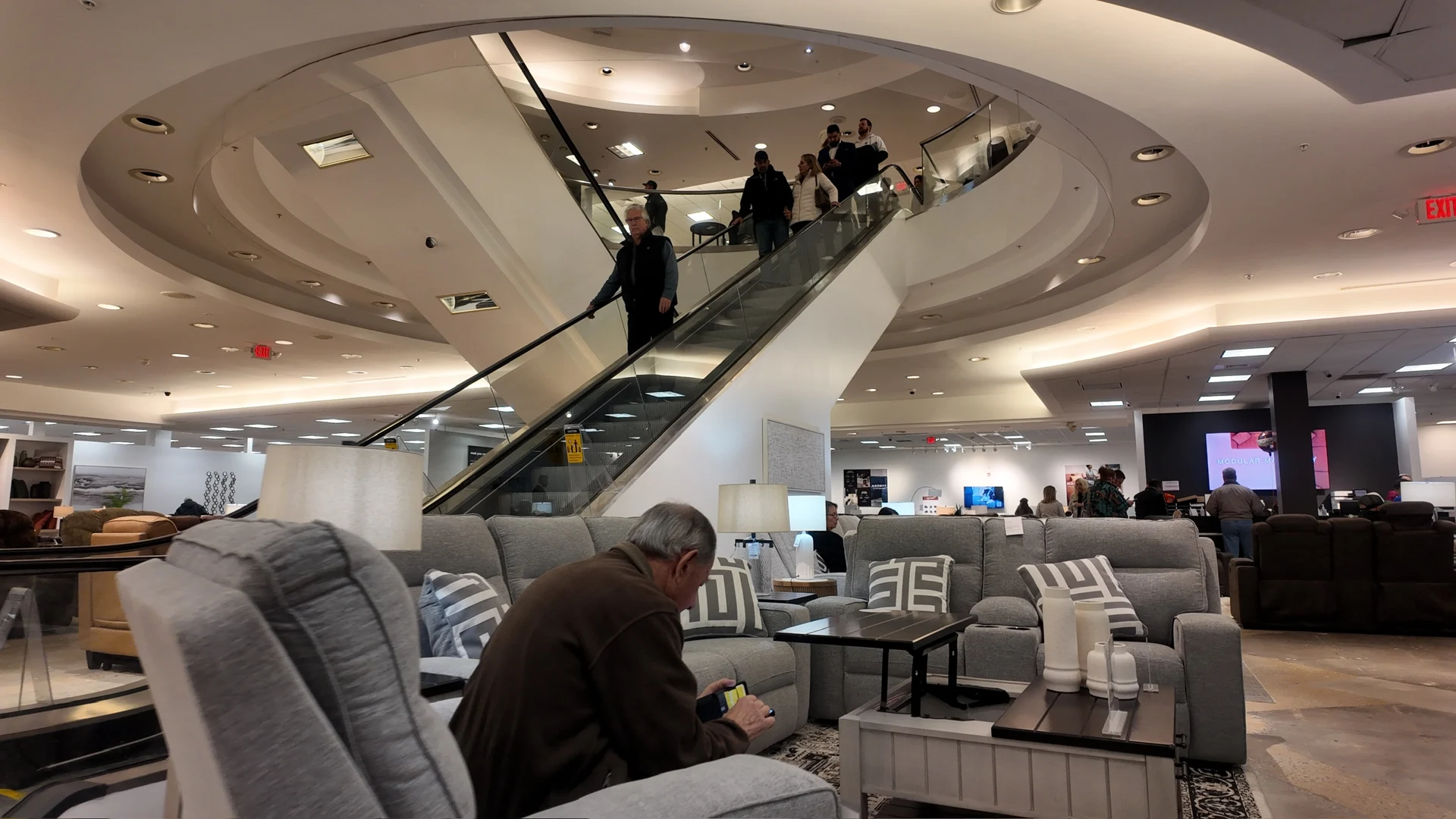 Ashley Furniture store interior with a curved escalator opening